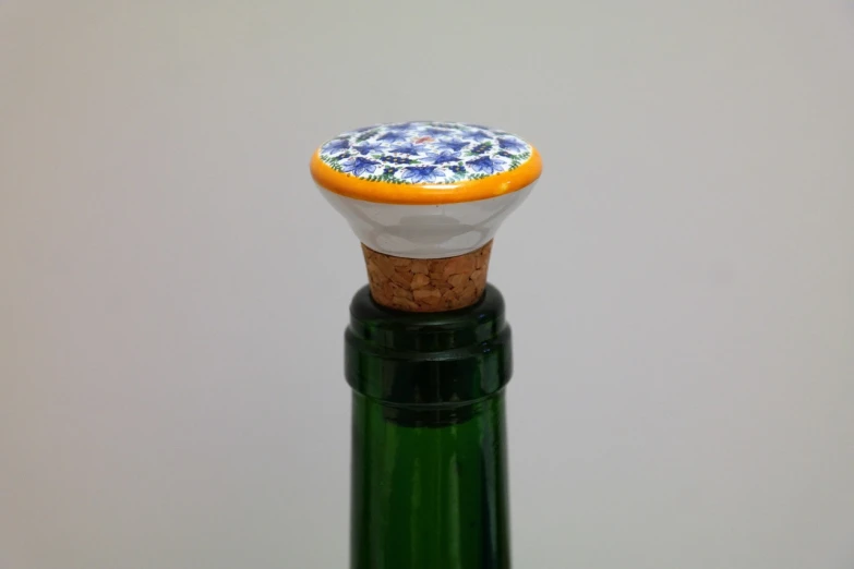 a close up of a bottle of wine with a cork stopper, inspired by Otakar Sedloň, cloisonnism, ceramic base, view from bottom to top, blue delphinium, bar tosz domiczek