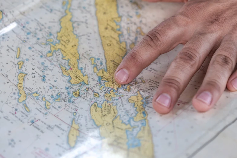 a close up of a person's hand on a map, by Christen Dalsgaard, regionalism, maritime, professional, geo