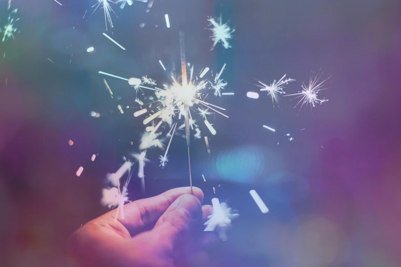 a person holding a sparkler in their hand, a picture, shutterstock, visual art, colorful refracted sparkles, holiday season, future!!, 🚀🚀🚀