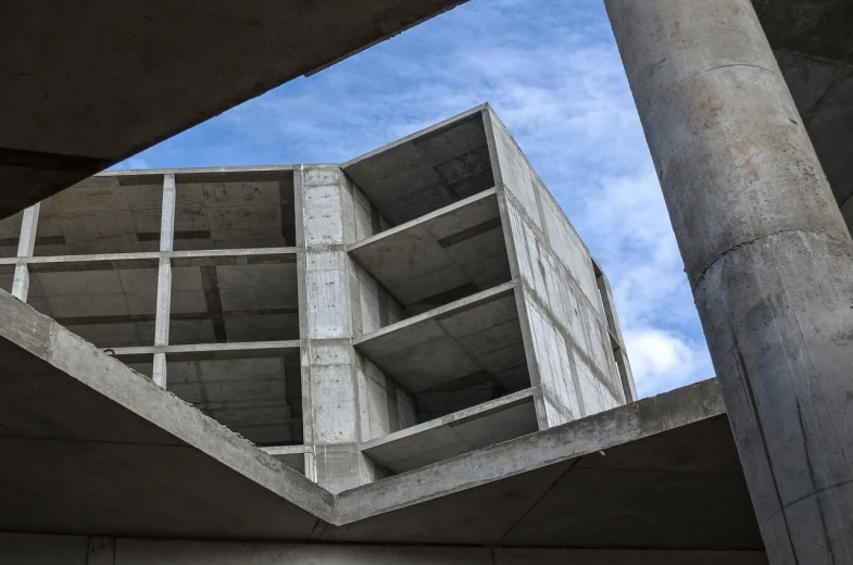 a close up of a building with a sky background, inspired by Tadao Ando, brutalism, interior view, under construction, diagonal composition, concrete housing