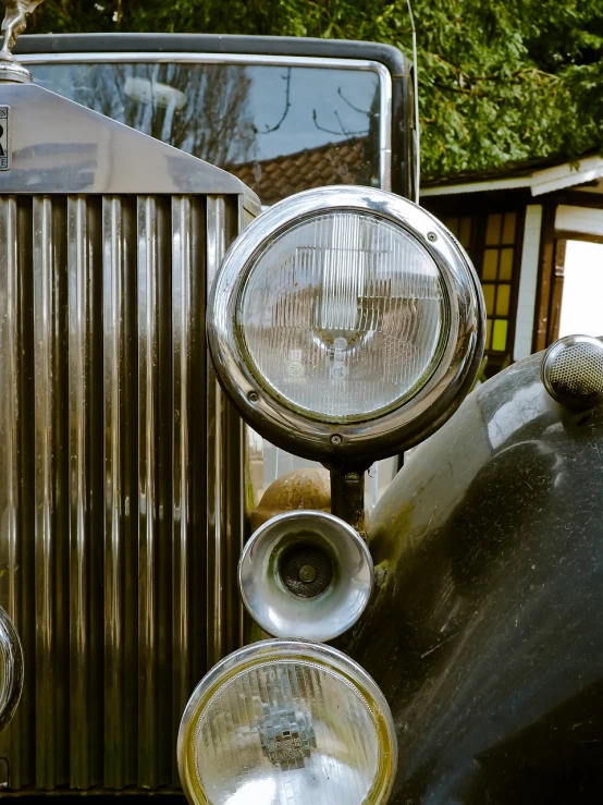 a close up of the front of a vintage car, by Etienne Delessert, photorealism, metal chrome, old english, lights, horn