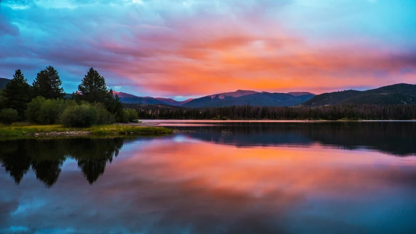 a large body of water with a mountain in the background, by Andrei Kolkoutine, shutterstock, beautiful new mexico sunset, new hampshire mountain, bright colors ultrawide lens, burning clouds