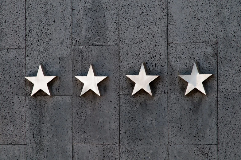 five stars mounted to the side of a building, a stock photo, fine art, on a dark rock background, four-dimensional, perfectly symmetrical, customers