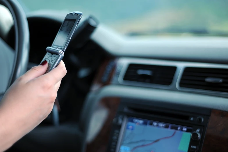 a person holding a cell phone in a car, by Adam Chmielowski, shutterstock, file photo, vibrating, text, “wide shot