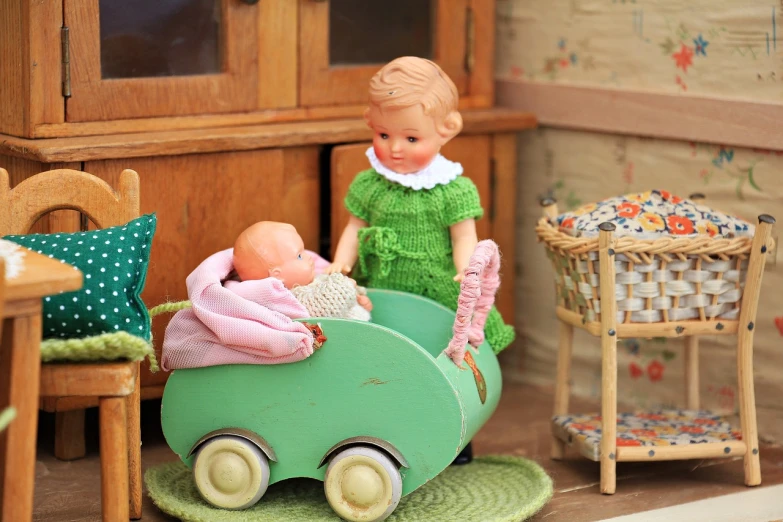 a couple of dolls that are sitting in a toy car, by Sylvia Wishart, flickr, inside a child's bedroom, green and warm theme, nursing, cart