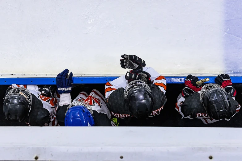 a row of hockey helmets lined up against a wall, a picture, by Jaakko Mattila, shutterstock, incoherents, laying on their back, athlete photography, curled up under the covers, spectators