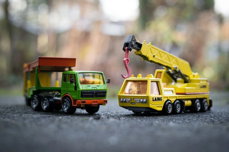 a couple of toy trucks sitting next to each other, by Richard Carline, crane, dramatic action shot, mini, lowres