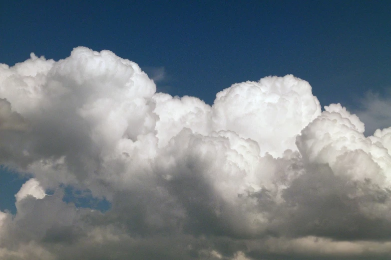 a plane flying through a cloudy blue sky, by Alexander Scott, flickr, precisionism, giant cumulonimbus cloud, lots of white cotton, bumps, a dragon made of clouds