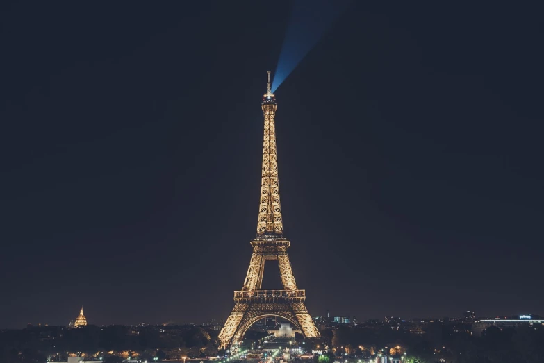 the eiffel tower is lit up at night, 8 k photo, high res photo, telephoto, post-processed