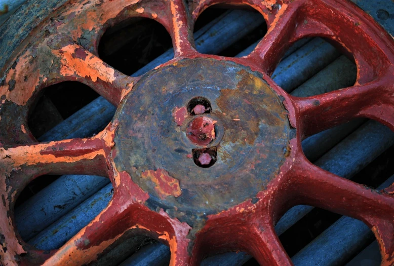 a rusted wheel with a hole in the center, a portrait, inspired by Max Ernst, flickr, red blue color scheme, high details photo