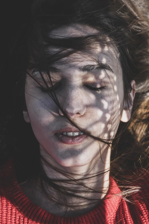 a woman with her hair blowing in the wind, a picture, inspired by Elsa Bleda, pexels contest winner, digital art, exhausted face close up, high angle closeup portrait, human face with bright red yes, lying down