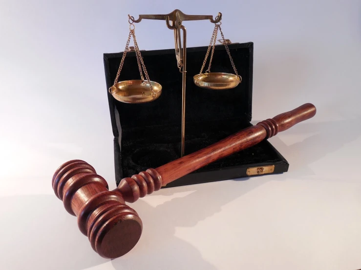 a wooden gaven sitting next to a scale of justice, a photo, highdetailed, instrument, hammer, set against a white background