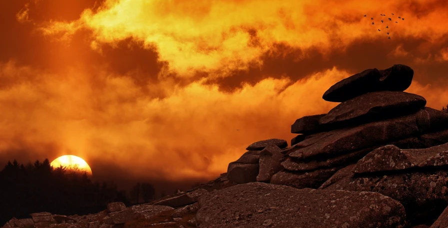 a pile of rocks sitting on top of a mountain under a cloudy sky, a picture, by Edwin Georgi, pexels contest winner, romanticism, coloured in orange fire, dramatic backlight, profile picture 1024px, red mist