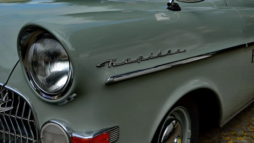 a classic car parked on a cobblestone street, by Karl Zerbe, unsplash, photorealism, closeup 4k, handwriting title on the left, flat shaped chrome relief, kerlee