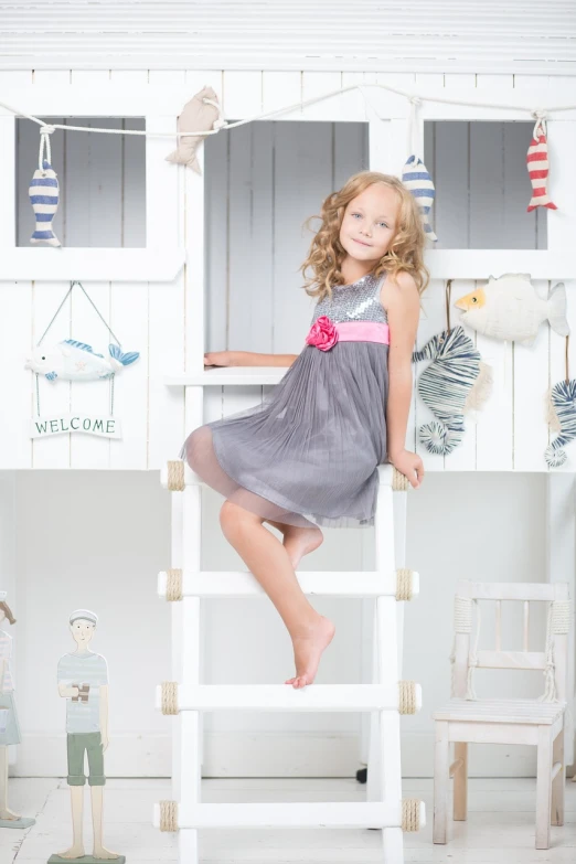 a little girl that is sitting on a ladder, a picture, by Josef Dande, happening, feminine girly dress, dressed in a gray, product introduction photo, sparkling