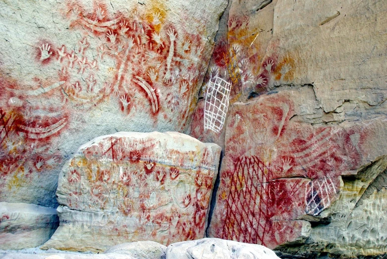 a close up of a rock with graffiti on it, a cave painting, by Joseph Yoakum, flickr, mingei, red and white marble panels, deep colours. ”, red webs, painting of white human figures