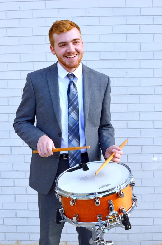 a man in a suit and tie holding a drum, by Matt Cavotta, kailee mandel, catalog photo, a handsome, christian