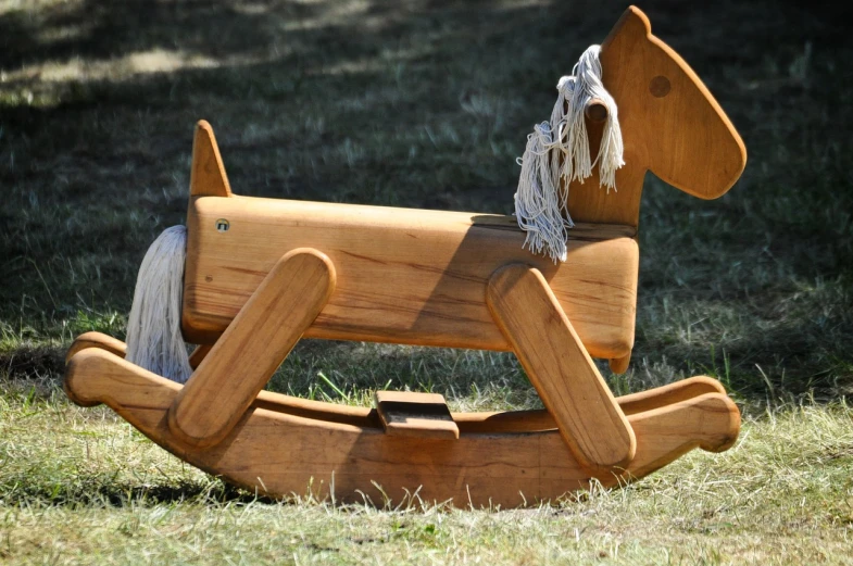 a wooden rocking horse sitting in the grass, by Alexander Fedosav, pixabay, figuration libre, prototype, 1 9 8 2, neck, pine