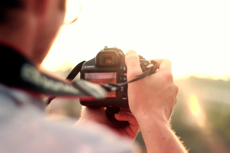 a man taking a picture with a camera, a picture, by Matthias Weischer, pexels, golden hour closeup photo, canon 1 d, back - lit, stock footage
