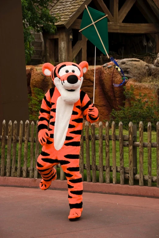 a person in a tiger costume holding a kite, inspired by Bill Watterson, shutterstock, sumatraism, disneyland, 2000s photo, digger land amusement park, running