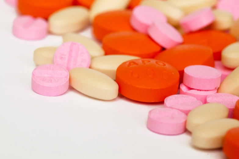 a pile of pills sitting on top of a table, antipodeans, pink and orange colors, medium detail, not cropped, bottom angle