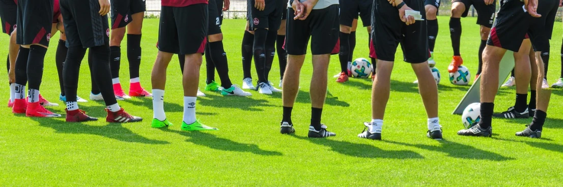 a group of young men standing on top of a lush green field, pixabay, antipodeans, soccer ball against her foot, train with maroon, clubs, in a row