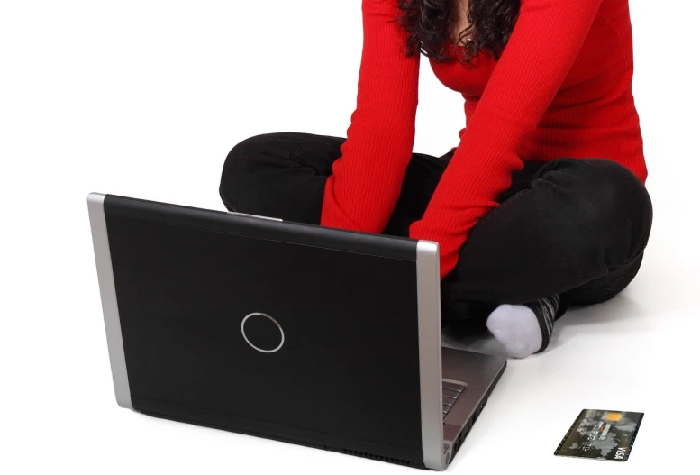 a woman sitting on the floor with a laptop, a photo, long hair and red shirt, istockphoto, hdd, sitting on a red button