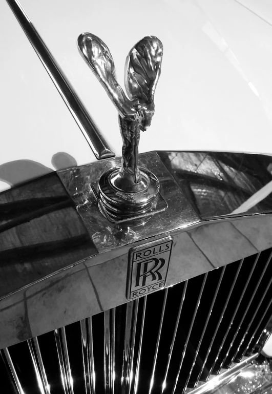 a close up of a hood ornament on a car, an art deco sculpture, by Robert Adamson, renaissance, icon black and white, wraith, featuring rhodium wires, iphone picture