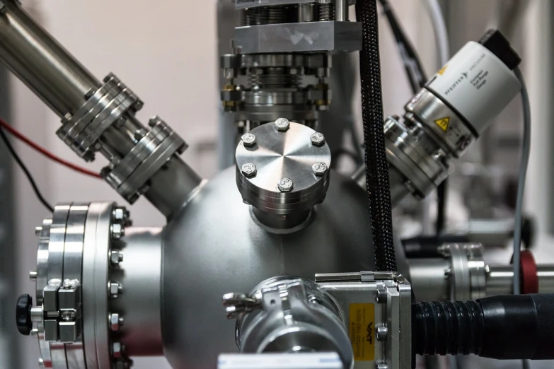 a close up of a metal object on a table, by Jakob Gauermann, flickr, hadron antimatter vacuum reactor, high detailed photo, in a laboratory, void manifold