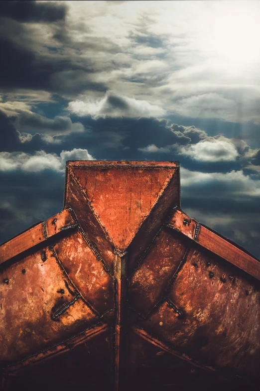 a rusted boat sitting under a cloudy sky, a portrait, shutterstock, roof background, dramatic reddish light, close up shot from the top, symetrical composition