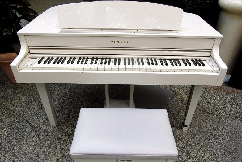 a white piano sitting next to a white stool, a photocopy, inspired by Kawai Gyokudō, pixabay, new musical instruments, white soft leather model, wikimedia commons, sony produced