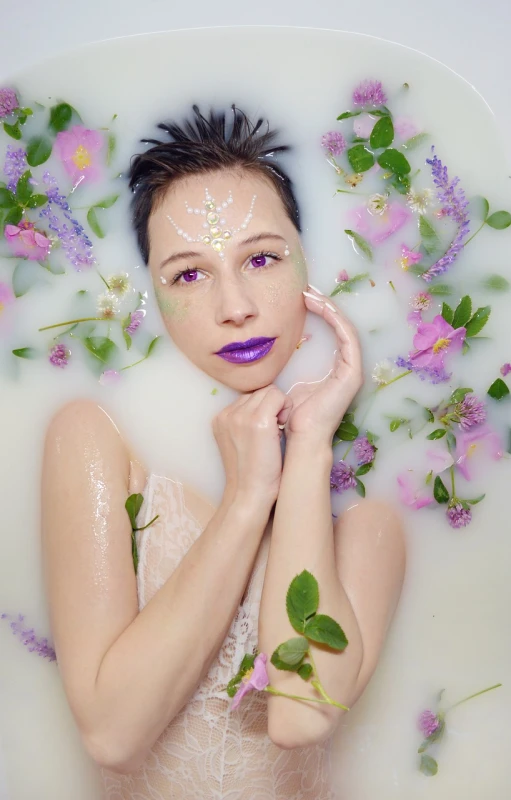 a woman laying in a bath filled with flowers, a portrait, inspired by Frederick Carl Frieseke, aestheticism, purple makeup, concept photoset, white shiny skin, closeup fantasy with water magic