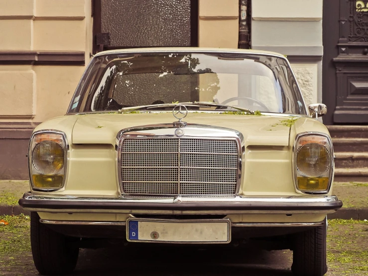 a car is parked in front of a building, a picture, by Matthias Weischer, trending on pixabay, arabesque, yellowed with age, mercedez benz, front flash, with a white muzzle