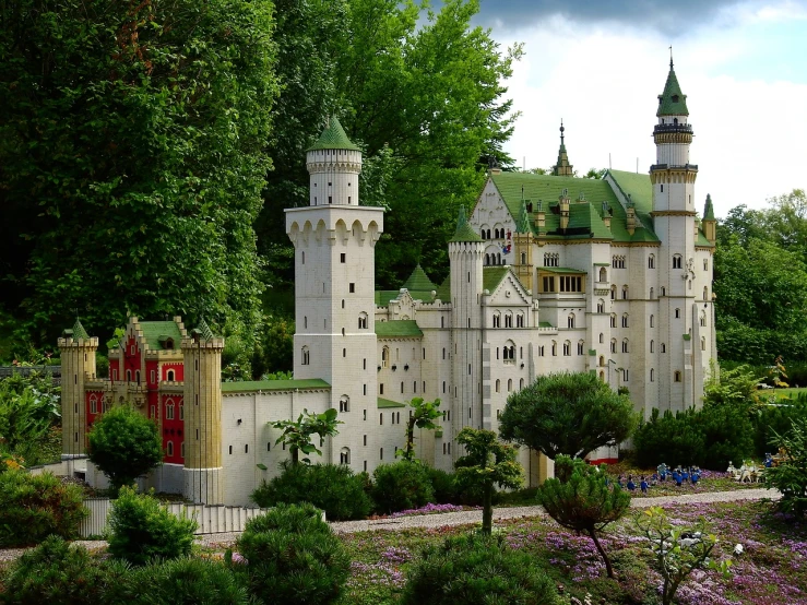 a model of a castle sitting on top of a lush green field, by Werner Gutzeit, flickr, legos, german forest, amusement park buildings, in style of mike savad”