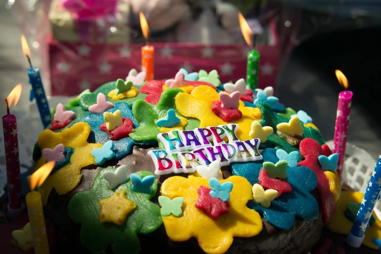 a close up of a birthday cake with candles, a picture, by Aleksander Gierymski, shutterstock, colorful mold, stock photo, animal - shaped cake, shining and happy atmosphere