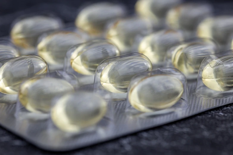 a pack of pills sitting on top of a table, a picture, by Jason Benjamin, shutterstock, bolts of bright yellow fish, crisp smooth lines, high detail product photo, detailed oil