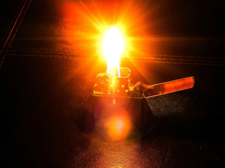 a lit lighter sitting on top of a table, light and space, toward the sun rays and caustics, good lighted photo, flame conjuring armored, dsrl photo