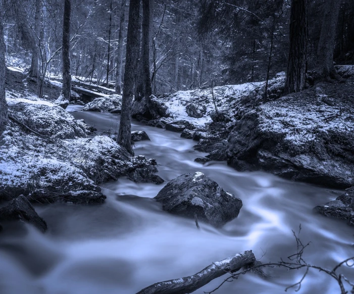 a stream running through a forest filled with snow, inspired by Ansel Adams, romanticism, blue hour, monochrome hdr, taken with sony a7r camera, river of blue fire