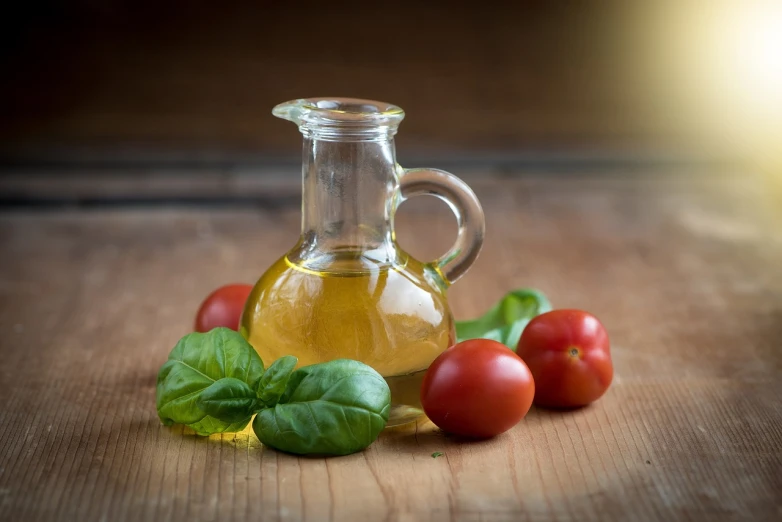 a bottle of olive oil and tomatoes on a table, a still life, shutterstock, basil, soft warm light, oil on wood, close-up product photo