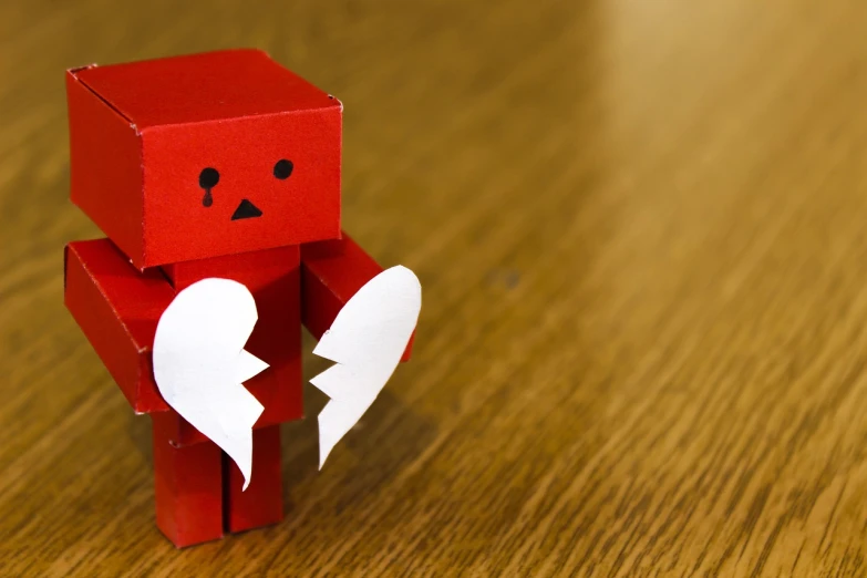 a red robot with a broken heart sitting on a table, pixabay, figuration libre, broken tiles, nendoroid, cardboard, crying many tears