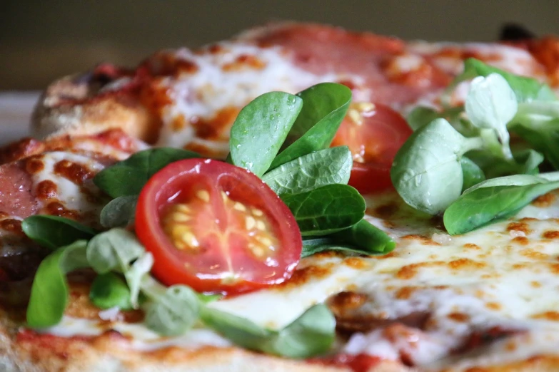 a pizza sitting on top of a white plate, by Tom Bonson, vibrant red and green colours, local close up, buttercup eating pizza, basil