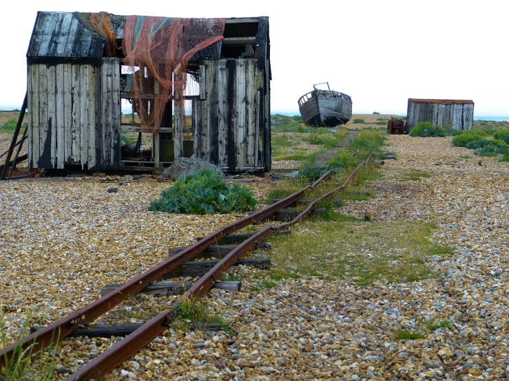 a small shack sitting on the side of a train track, by Richard Carline, shutterstock, shipwrecks, highfleet, bent rusted iron, huts