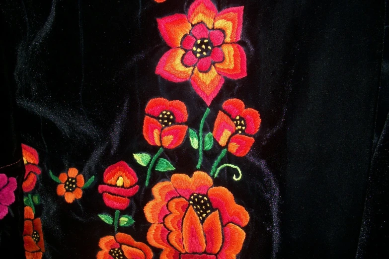 a close up of a jacket with flowers on it, a screenshot, inspired by Maksimilijan Vanka, flickr, folk art, black velvet, orange flowers, ivan bolivian, ussr