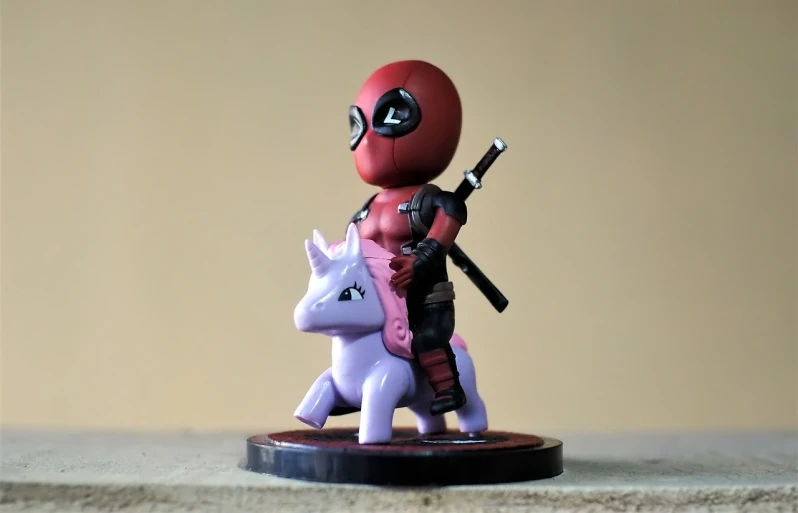 a figurine of a deadpool riding a unicorn, unsplash, chibi proportions, me, portrait mode photo, hawkeye