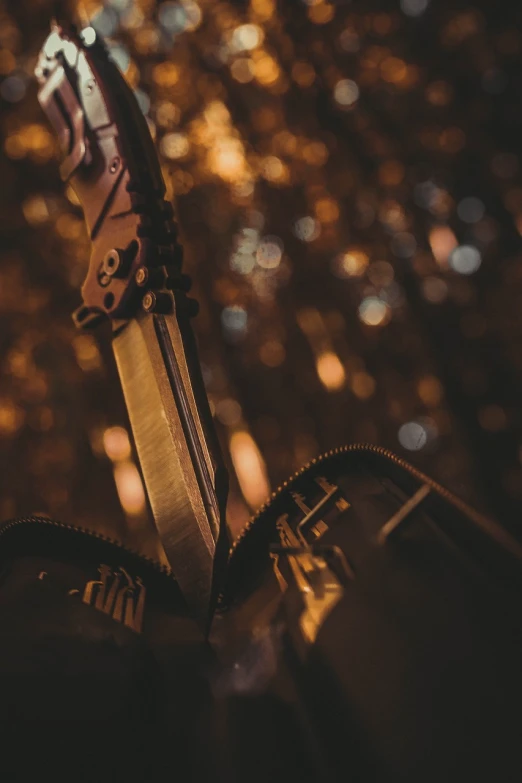 a close up of a knife sticking out of a bag, a picture, by Adam Marczyński, unsplash, digital art, steampunk katana, evening lighting, holding pdw, ✨🕌🌙