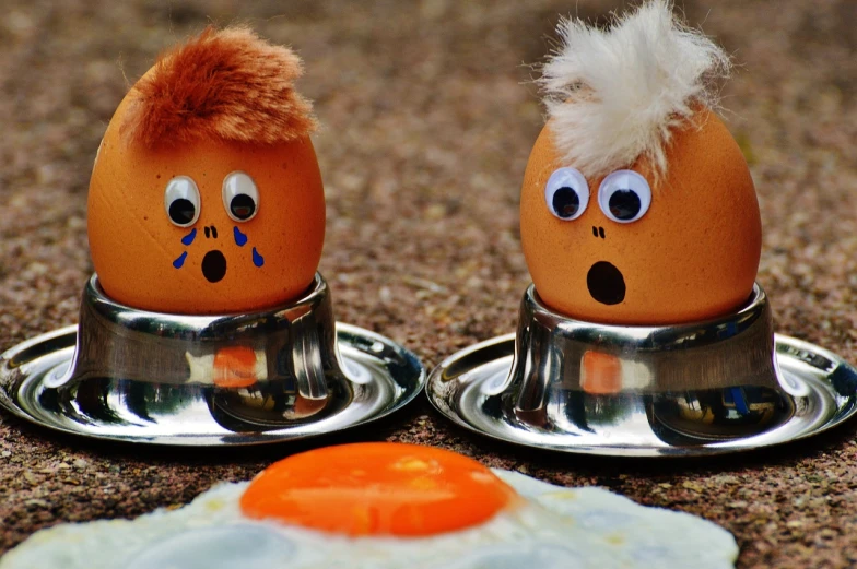 a couple of eggs sitting next to each other, a cartoon, trending on pixabay, digital art, beans in his eyes sockets, the decisive moment, orange head, pots and pans
