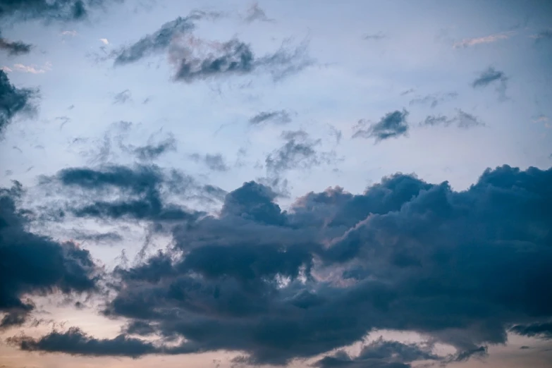 a large jetliner flying through a cloudy sky, by Etienne Delessert, unsplash, romanticism, blue sunset, cumulus, the cloudy moonlit sky, panorama view of the sky