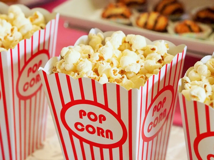 three boxes of popcorn sitting on top of a table, a cartoon, by Rhea Carmi, pexels, photo of the cinema screen, crisps, red and white color theme, 🦩🪐🐞👩🏻🦳