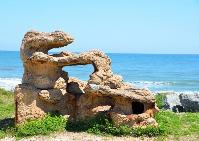 a rock formation on a beach with the ocean in the background, an abstract sculpture, romanticism, apulia, ancient japanese architecture, set photo, portlet photo