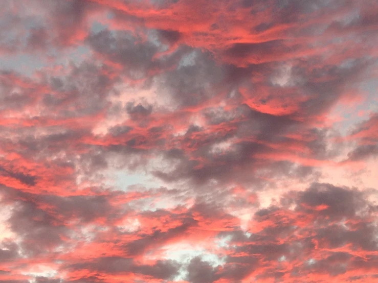 there is a plane that is flying in the sky, by Charlotte Harding, flickr, romanticism, dramatic pink clouds, shades of red, layered stratocumulus clouds, at gentle dawn red light